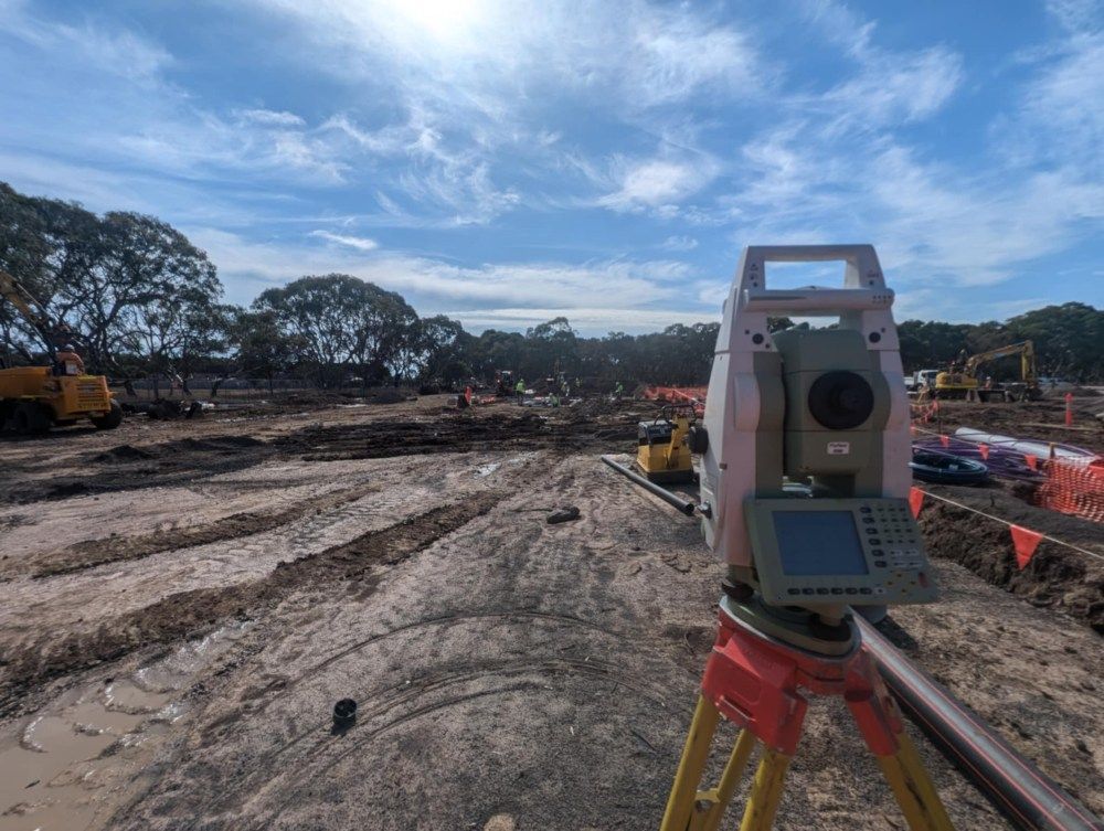 A Total Station Is Sitting On Top Of A Tripod In A Construction Site — Point to Point Surveying In Tatura, VIC