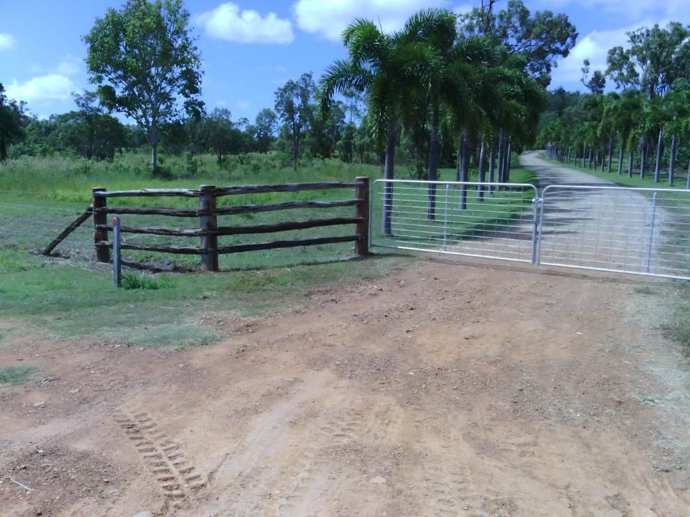 A Dirt Road With A Wooden Fence And A Metal Gate — Mini Excavator Hire & Rural Fencing In Bungundarra, QLD