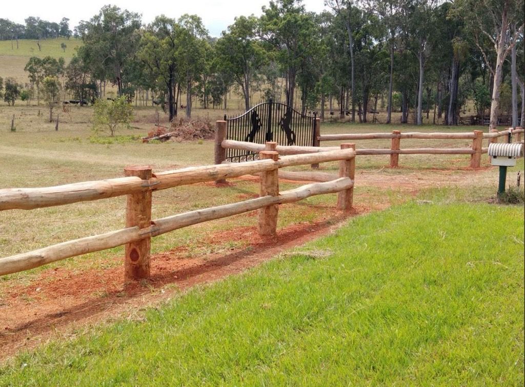 A Wooden Fence With Logs and Black Horse Gates — Mini Excavator Hire & Rural Fencing In Bungundarra, QLD