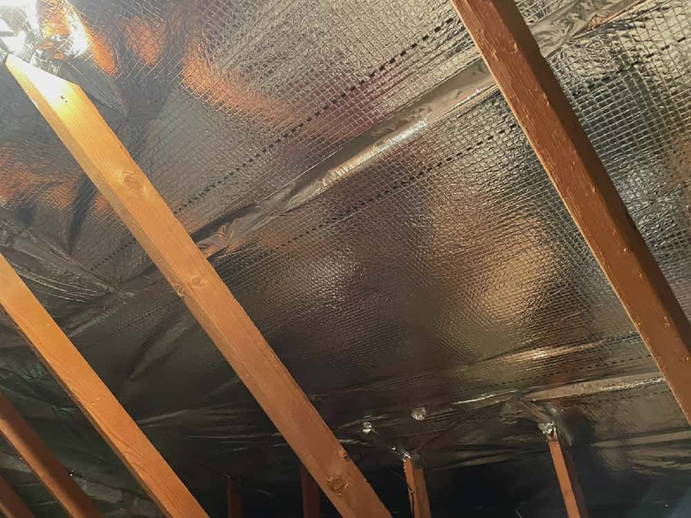 Inside of a house ceiling covered in foil thermal sheets.