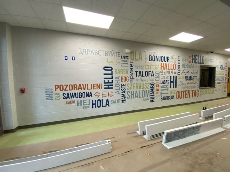 Concrete bridge supports along a road with a car. Gray and beige tones, wet pavement.