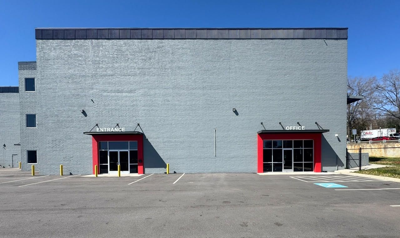 A large brick building with a parking lot in front of it.
