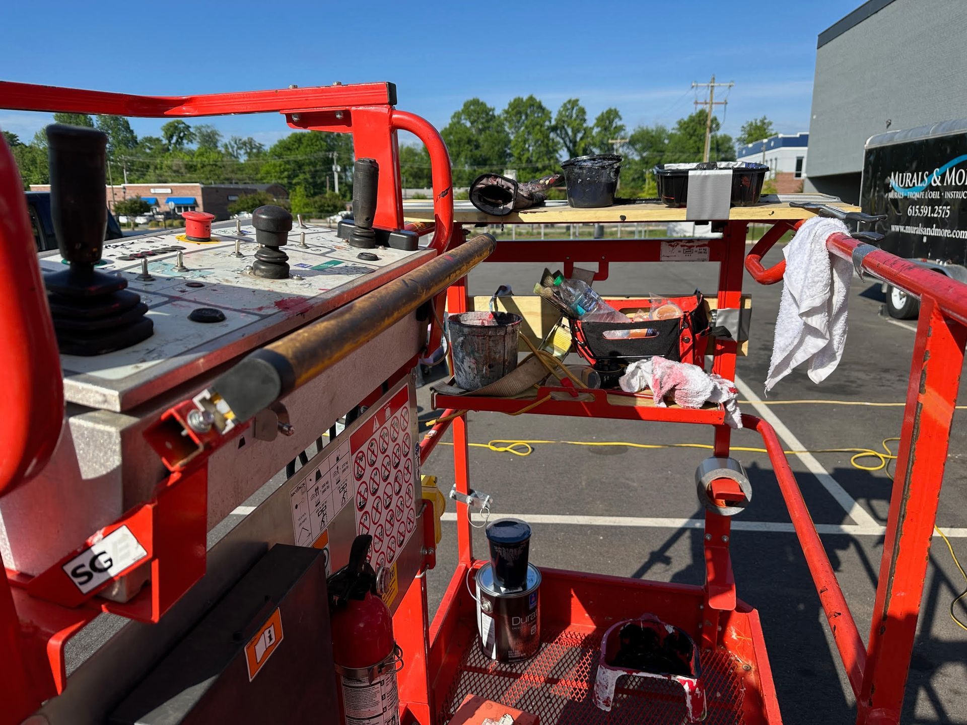 A red bucket truck is parked in a parking lot.