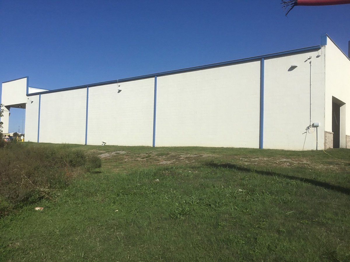 Mural Artist Paints Exterior Wall Mural at Camel Express Car Wash TN