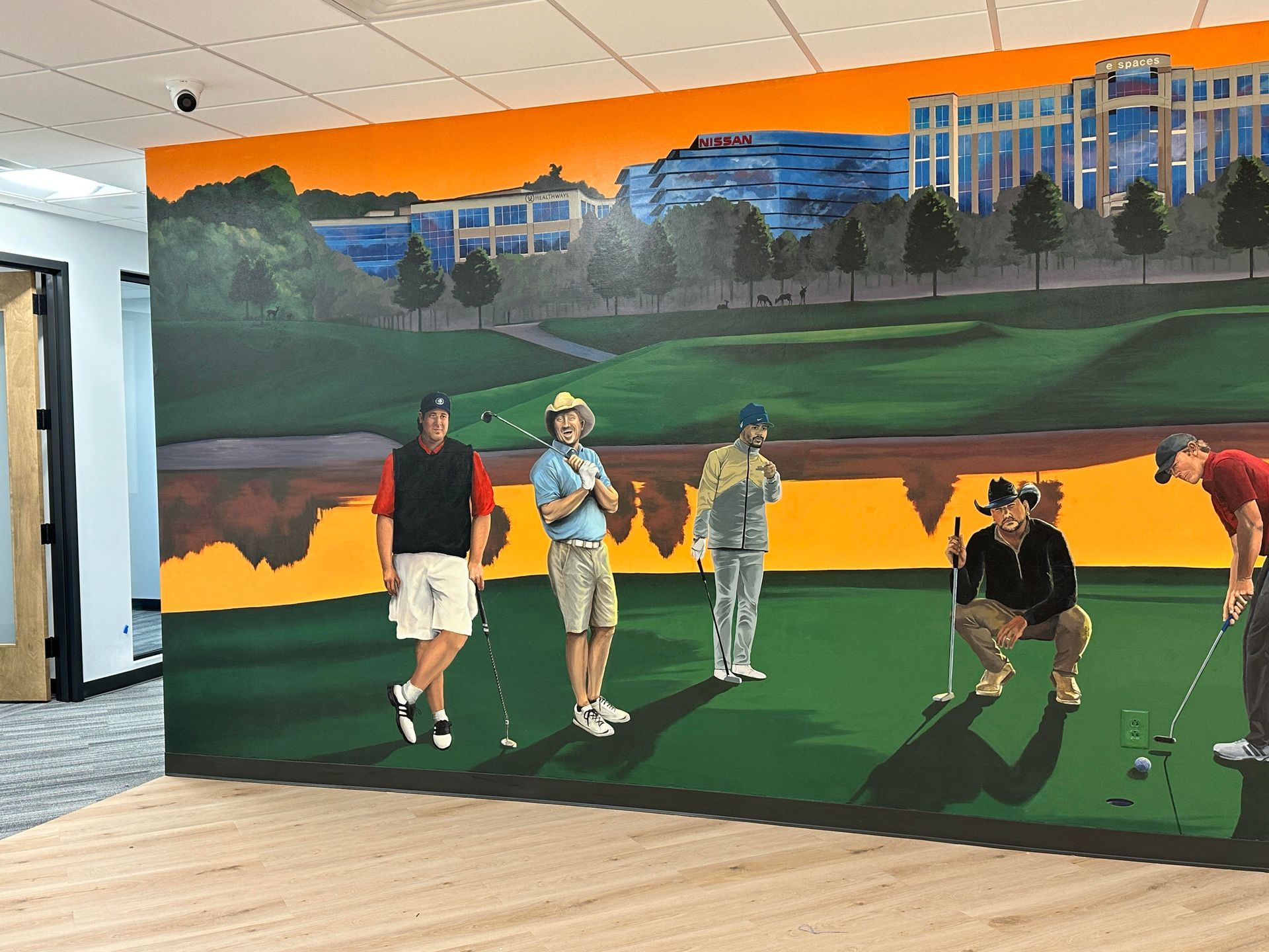 Mural of golfers on a green with a building in the background. Bright colors and an orange sky.