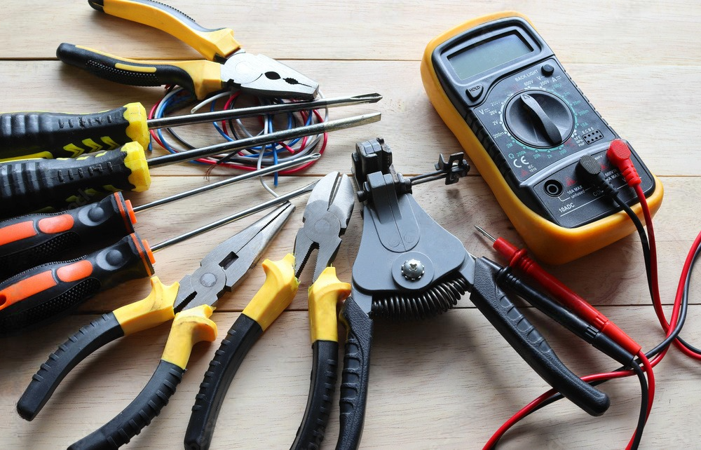 A bunch of tools are sitting on a wooden table.