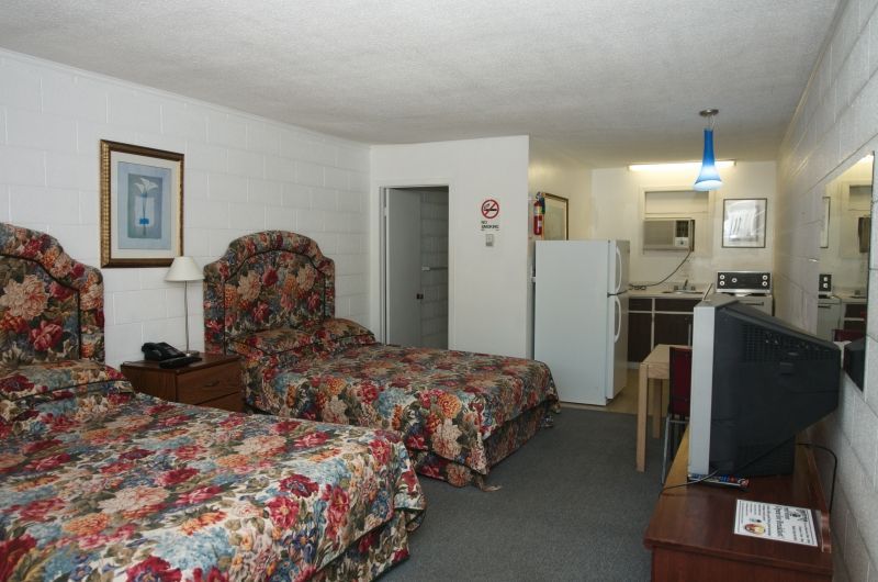 A hotel room with two beds and a flat screen tv