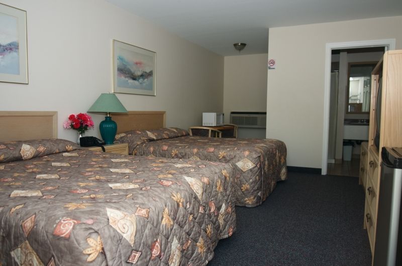 A hotel room with two beds and a lamp