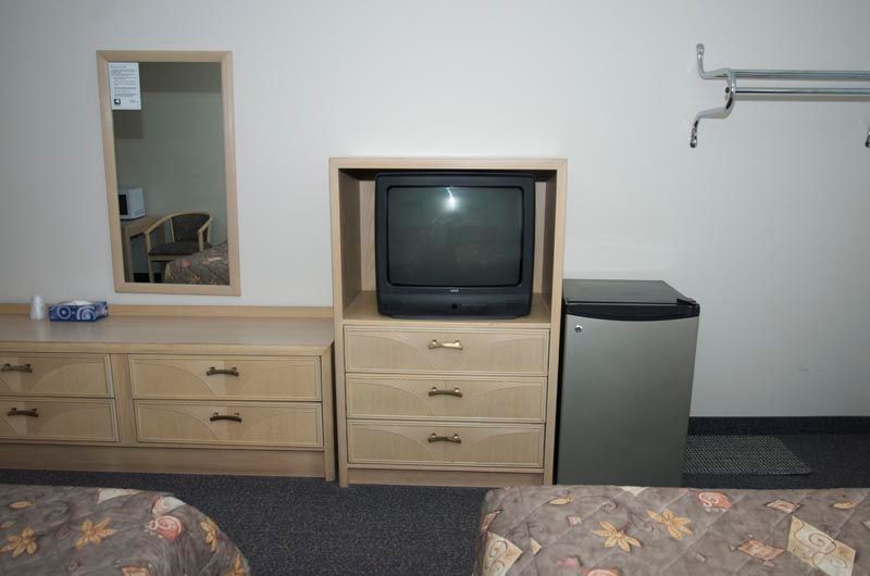 A hotel room with two beds and a flat screen tv