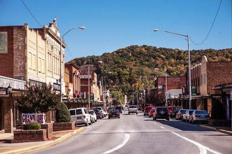 A busy street in a small town with a mountain in the background.