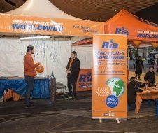 A group of people are standing in front of a ria booth.