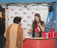 A woman is standing behind a counter talking to a woman.