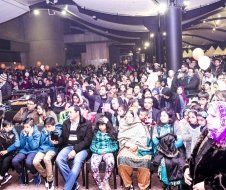 A large group of people are sitting in chairs in a room.