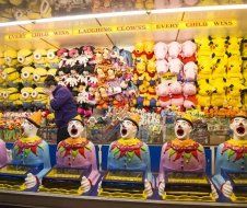 A man is standing in front of a display of stuffed animals.