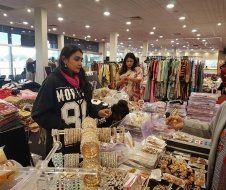 A woman is standing in a store looking at jewelry.