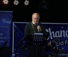 A man is standing in front of a microphone on a stage.