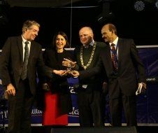 A group of people in suits and ties are standing next to each other on a stage.
