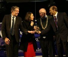 A group of people in suits and ties are standing next to each other and shaking hands.