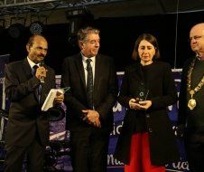 A group of people are standing next to each other on a stage.