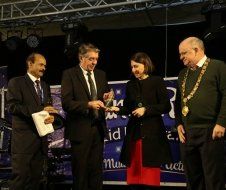 A group of people standing next to each other on a stage.