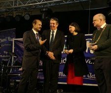 A group of people standing on a stage talking to each other