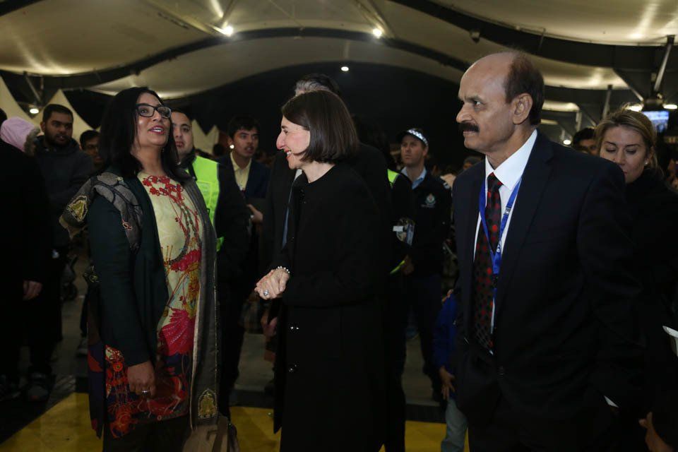 A group of people are standing in a room talking to each other.