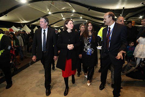 A group of people are walking in a room.