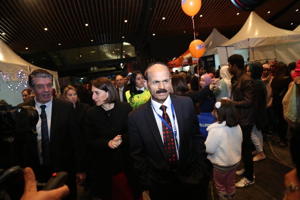 A man in a suit and tie is walking through a crowd of people