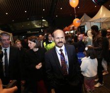 A man in a suit and tie is walking through a crowd of people.