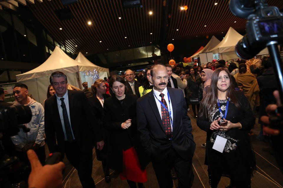 A group of people are walking through a crowded room.