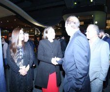 A group of people are standing around talking to each other.