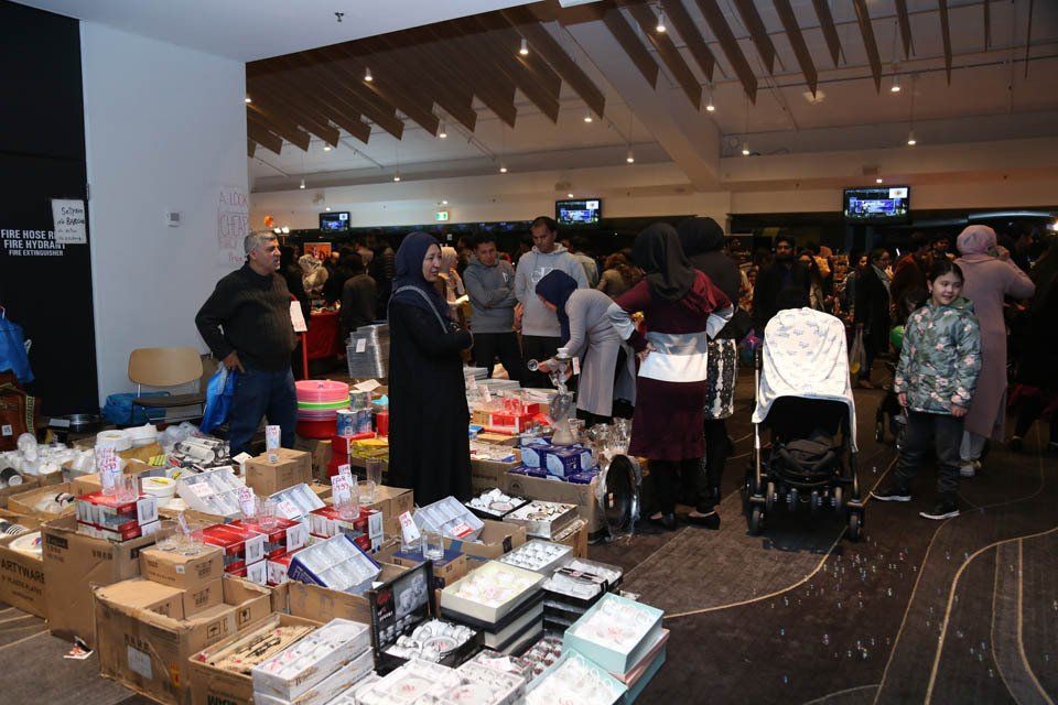 A group of people are standing around a table full of boxes.