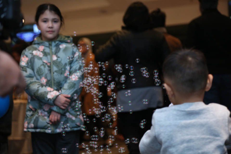 A girl and a boy are playing with soap bubbles