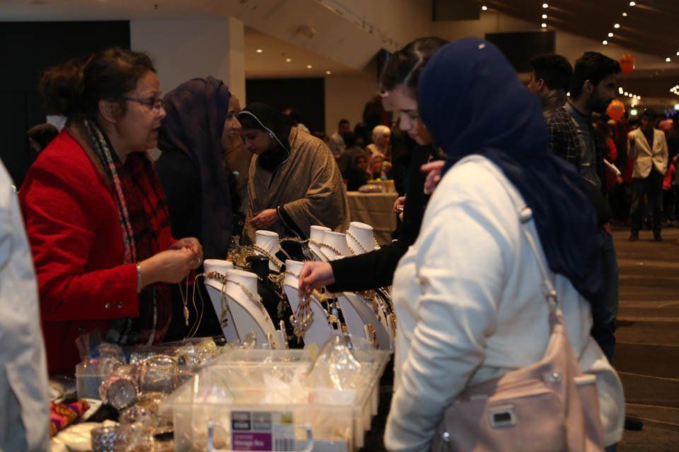 A group of people are looking at jewelry at a market