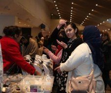 A group of people are standing around a table at a market.