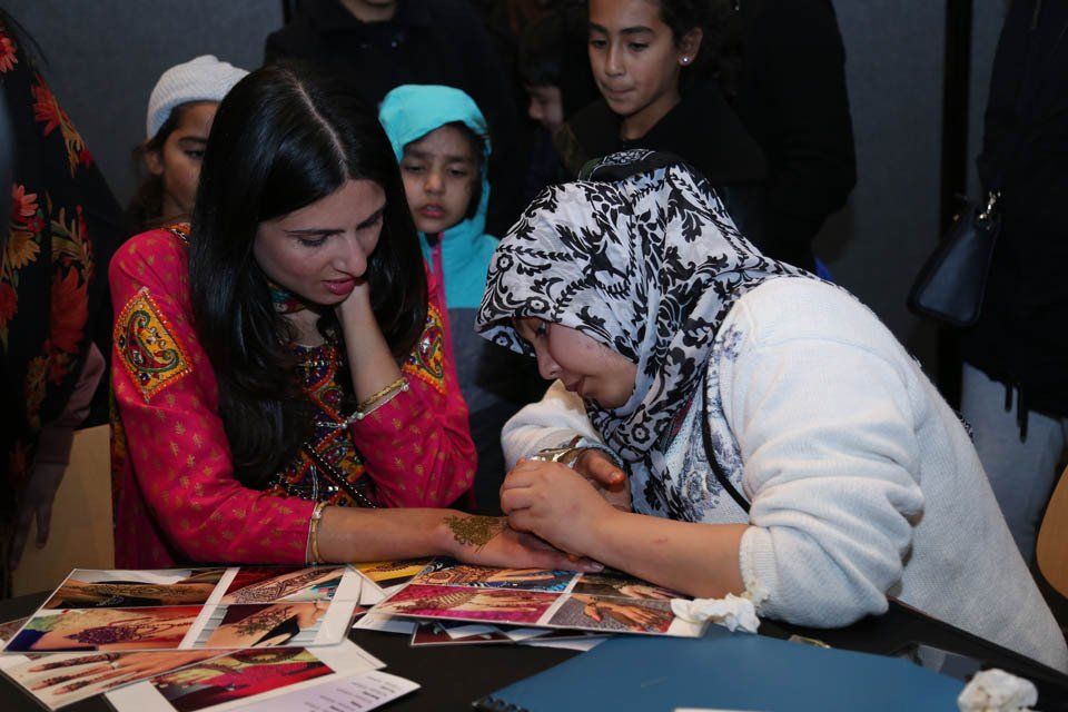 Two women are sitting at a table looking at pictures