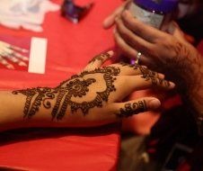 A person is applying henna to a woman 's hand
