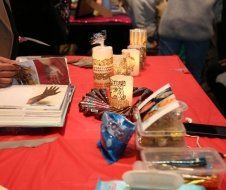 A table with a red table cloth and candles on it