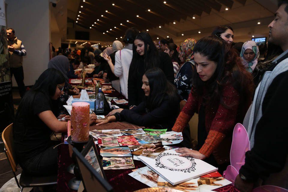 A group of people are gathered around a table at a convention