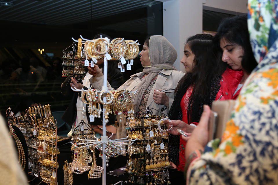 A group of women are looking at jewelry in a store.