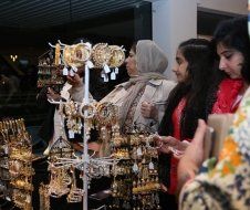 A group of women are standing in front of a display of jewelry.