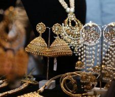 A variety of gold jewelry is displayed on a table.