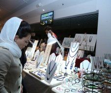 A woman is standing in front of a table full of jewelry.