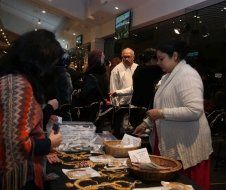 A group of people are standing around a table with baskets of food.