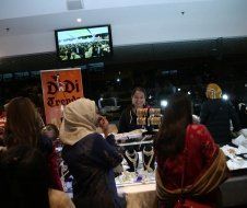 A group of women are standing around a table in a room.