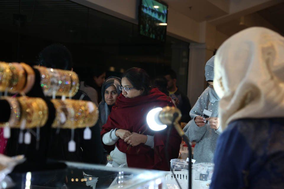 A group of people are looking at bracelets in a store.