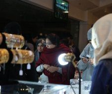 A group of people are looking at bracelets in a store.
