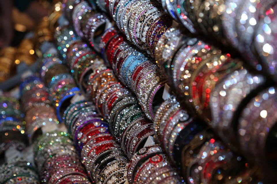 A bunch of bracelets are stacked on top of each other in a store.