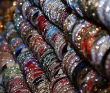 A bunch of bracelets are stacked on top of each other in a store.