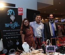 A group of people are posing for a picture in front of a jewelry store.